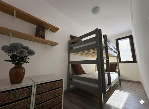 une chambre avec des lits superposés et un vase avec une plante dans l'établissement 8 ARBOUSIERS VILLA 17, à Bonifacio