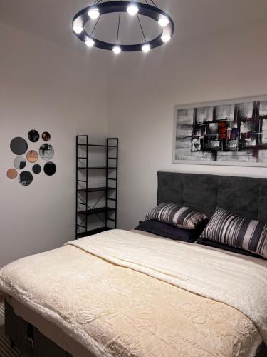 a bedroom with a large bed with aendant light at Oakline Apartments in Pristina