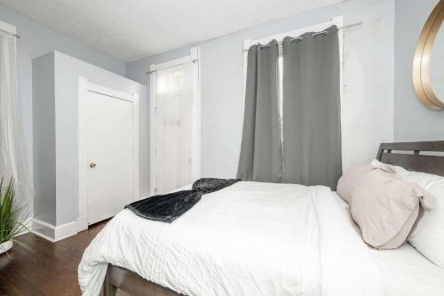 a bedroom with a white bed and a window at Queen City Suites 1 - For 3 in Cincinnati