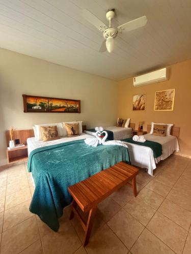 a bedroom with two beds and a bench in it at Apt Flat 225 Condomínio Pedra do Rodeadouro in Bonito