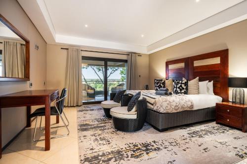 a bedroom with a king sized bed and a desk at Simanya River Lodge in Kanyekama