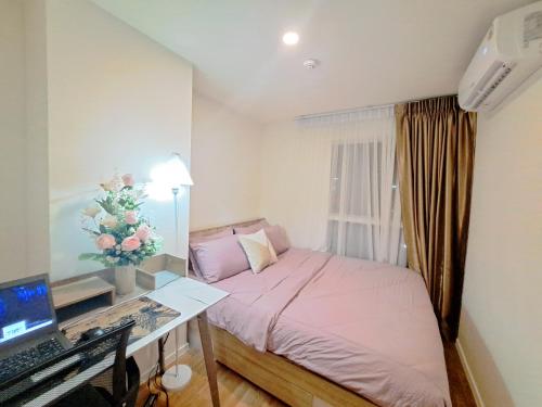 a bedroom with a bed and a desk with a computer at A family room at Lumpini Ville Sukhumvit 101-1 by Pikul in Bangkok