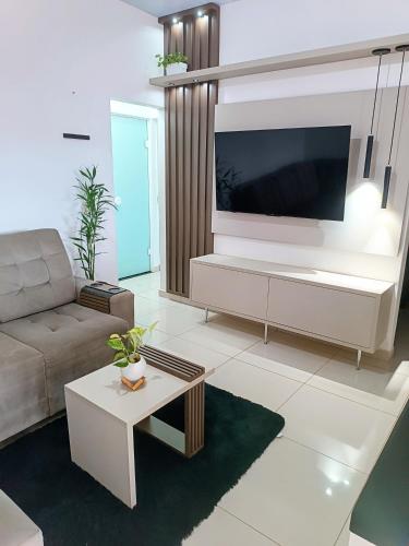 a living room with a large flat screen tv at Casa Completa em Foz do Iguaçu in Foz do Iguaçu