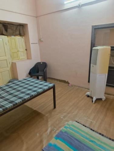a room with a bed and a chair in it at Arihant Guest House in Ujjain