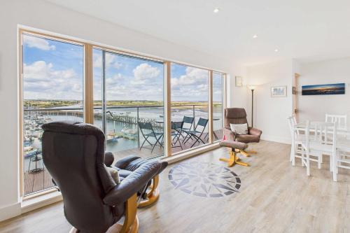 een woonkamer met een balkon met een tafel en stoelen bij Host & Stay - Becalmed in Amble