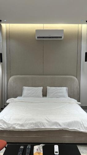 a bed in a room with two remote controls at Vant in Riyadh