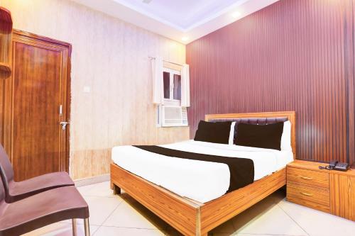 a bedroom with a bed and a chair at Hotel O Blue Stone Near Singapore Mall Lucknow in Gomti Nagar