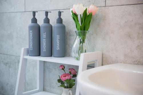 three bottles sitting on a shelf next to a white chair at Stylish Studio in the Heart of Stamford Perfect Location in Stamford