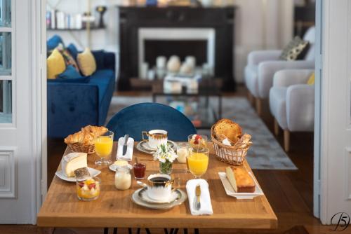 カンブレーにあるLa Demeure Numéro 5の朝食用の食材とオレンジジュースを用意した朝食用テーブル