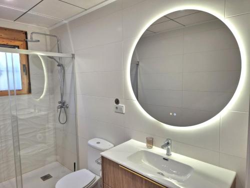 a white bathroom with a sink and a mirror at La Casa de la Huerta de Redován in Redován
