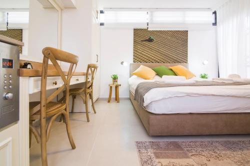 a bedroom with a bed and a desk and a table at HaBaitBe Matityahu By Domus in Beer Sheva