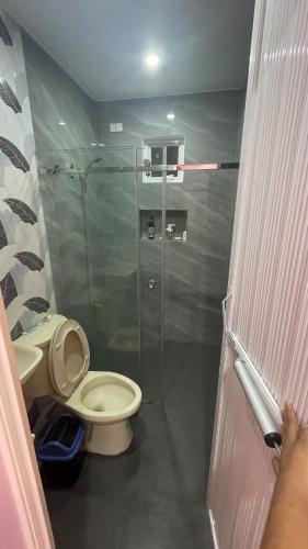 a bathroom with a toilet and a glass shower at Silang Guest house in Bangkal