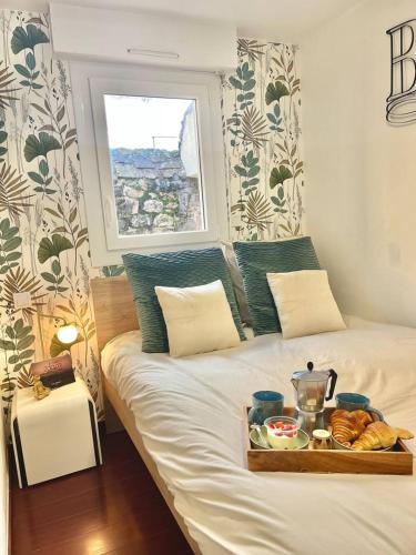 ein Bett mit einem Tablett mit Essen drauf in der Unterkunft Le cottage in Saint-Brieuc