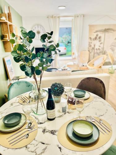 einen Tisch mit Tellern und Weingläsern darauf in der Unterkunft Le cottage in Saint-Brieuc