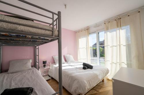 a bedroom with two bunk beds and a window at La Villa Océane, familiale & piscine privée in Guidel