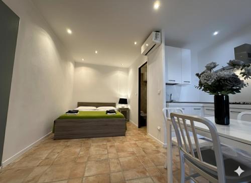 une chambre avec un lit et une table et une cuisine dans l'établissement 8 ARBOUSIERS VILLA 20, à Bonifacio