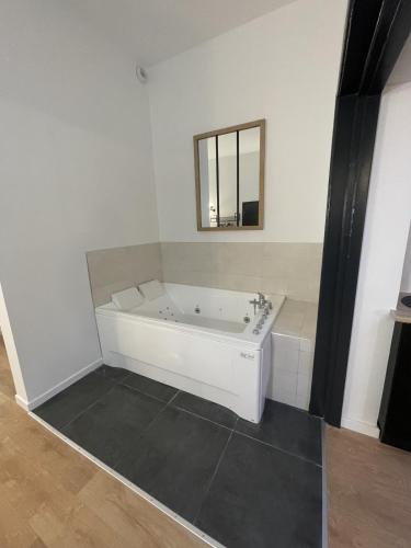 a white bathroom with a tub and a mirror at Calais Wilson 2 - Studio Balneo 2p in Calais