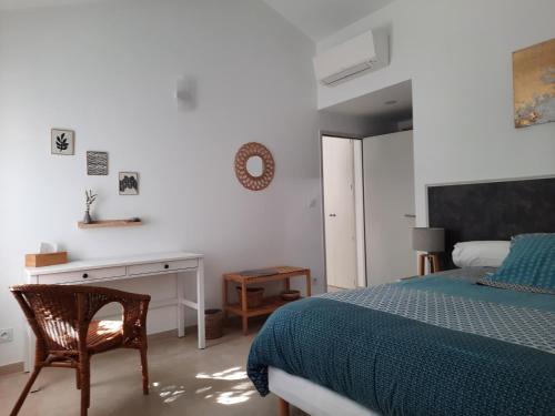 a bedroom with a bed and a desk and a chair at Gîte le Relais d'Eden in Barbentane