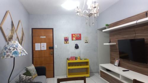 a living room with a tv and a chandelier at Ótimo apartamento aconchegante in São Luís