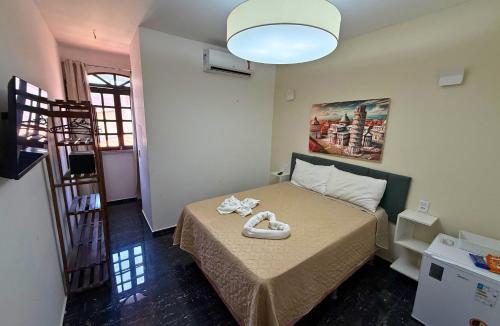 a bedroom with a bed with shoes on it at Pousada Vila Italia - Porto da Dunas in Aquiraz
