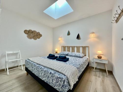 ein Schlafzimmer mit einem Bett mit blauen Kissen darauf in der Unterkunft Rincon del Mar - Maison & spa privatif in Saint-Hilaire-de-Riez