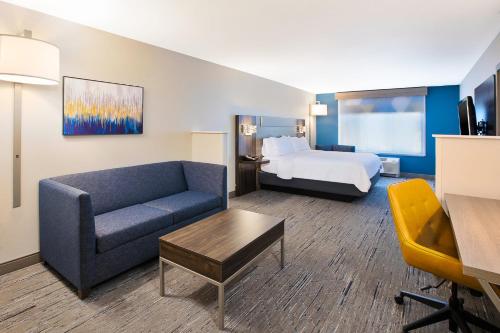 a hotel room with a couch and a bed at Holiday Inn Express & Suites Sioux Falls Southwest by IHG in Sioux Falls