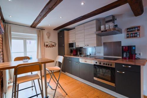 a kitchen with stainless steel appliances and a wooden table at RefuKium alte Gerberei - Im Zentrum von Weißenburg in Weißenburg in Bayern