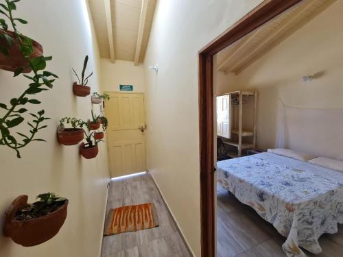 a bedroom with a bed and potted plants on the wall at Habitación con baño privado in Barichara