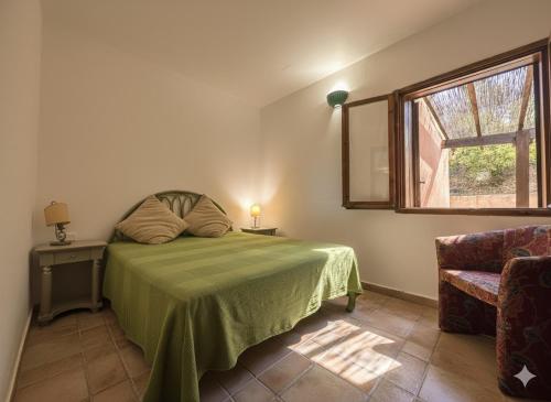 une chambre avec un lit, une fenêtre et une chaise dans l'établissement 8 ARBOUSIERS VILLA 21, à Bonifacio