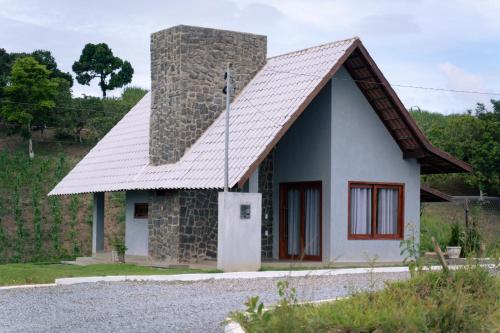 une petite maison en pierre avec un toit en métal dans l'établissement Ecoville Coracao da Serra, à Areia