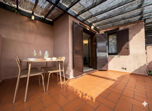 une salle à manger avec une table et des chaises sur un patio dans l'établissement 8 ARBOUSIERS VILLA 21, à Bonifacio