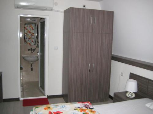 a bedroom with a bed and a bathroom with a sink at Къща за гости Семейство Петрови in Kalofer