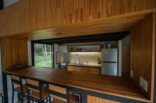 eine Küche mit einer Theke mit Stühlen und einem Kühlschrank in der Unterkunft Cabaña estilo escandinavo in Santa Ana