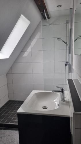 een witte badkamer met een wastafel en een douche bij Ferienwohnung Luitpold 21 in Edenkoben