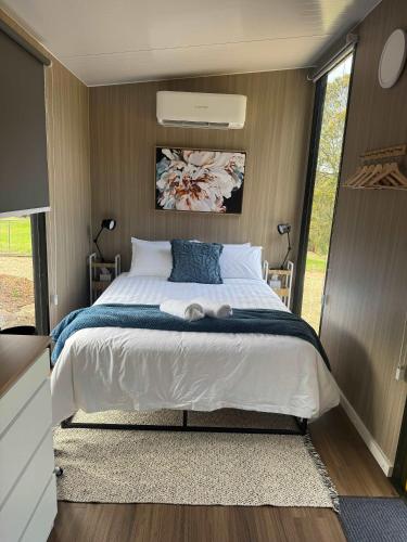 a bedroom with a large bed in a caravan at Gruyere Falls by Tiny Away in Gruyere