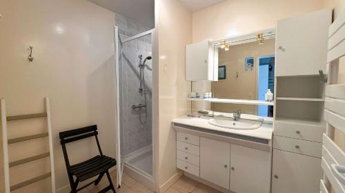 Un baño con ducha, lavabo y espejo. en Charmante location à deux pas de la plage, en Rivedoux-Plage