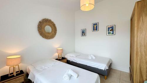 una habitación con dos camas y un espejo en Charmante location à deux pas de la plage, en Rivedoux-Plage