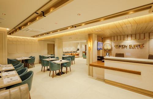 a restaurant with green chairs and tables and a counter at Olwen Suites in Cochin