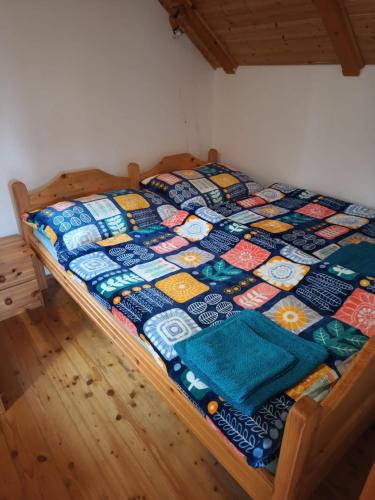 a bed with a quilt on it in a room at Chata Jindřiška in Borušov