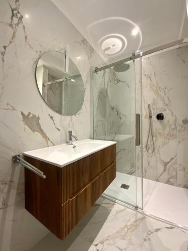 a bathroom with a sink and a shower and a mirror at Trieste City 1 in Trieste