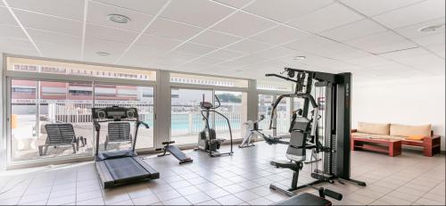 ein Fitnessstudio mit Laufbändern und Cardiogeräten in einem Gebäude in der Unterkunft T2 4 couchages Port du Cap d'Agde , climatisation , piscine in Cap d'Agde
