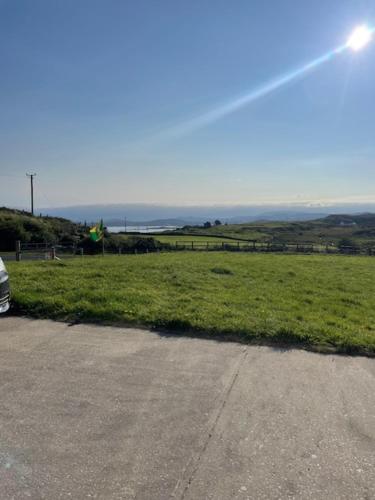 a field of green grass next to a road at Lackaghmore House in Portnoo