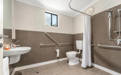a bathroom with a toilet and a sink and a shower at Beach Shack 6 in Preston Beach