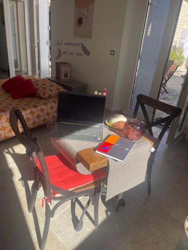 a table with a laptop computer on it in a room at L'appart Thé - Charme apaisant au coeur des Alpilles in Paradou