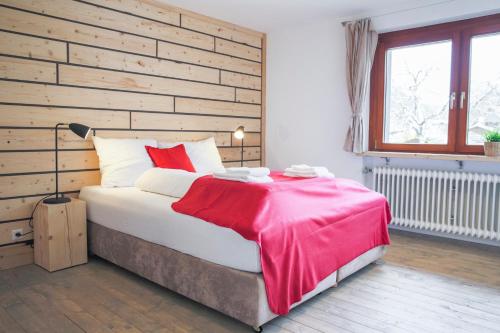 圣布拉辛Menzenschwand Kapellenweg by Kuckucksnest的卧室里有一张床，床上铺着一条红毯子
