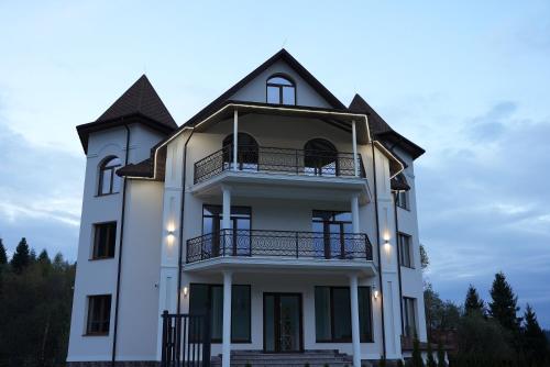 a white house with a balcony on top of it at Elata Aparts in Skhidnitsa