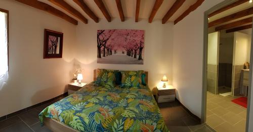 ein Schlafzimmer mit einem Bett und einem Gemälde an der Wand in der Unterkunft Gite Jardin De Pomarede in Prigonrieux