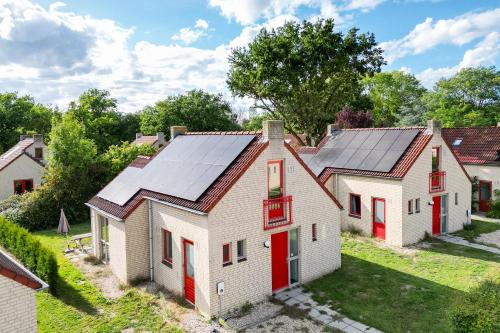 an old house with solar panels on its roof at Groenlake Villa 6p Vakantie bungalow in Ewijk