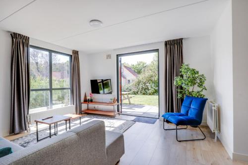 a living room with a couch and a blue chair at Groenlake Villa 6p Vakantie bungalow in Ewijk