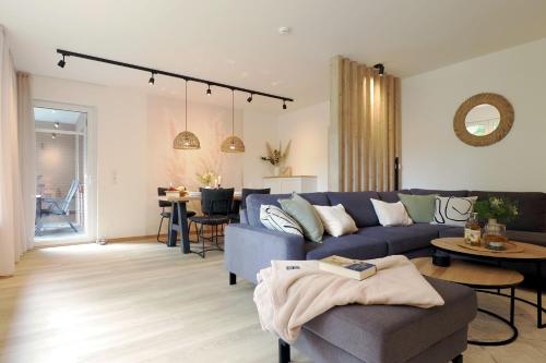 a living room with a blue couch and a table at "Skandi-Lounge" - Naturnahe Ferienwohnung mit Kaffeebar, schnellem Internet und Wallbox in Beverstedt
